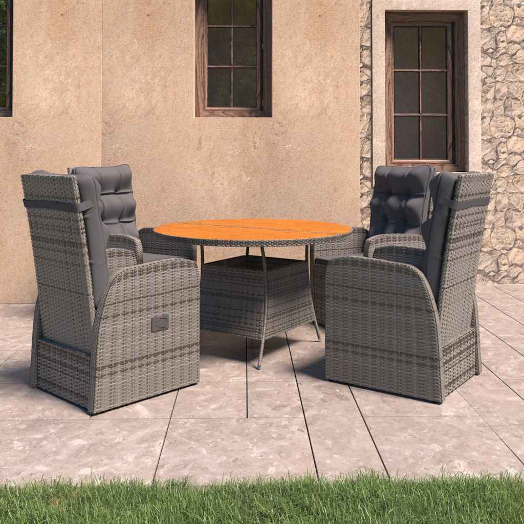 Grey poly rattan outdoor dining set with cushions, side view on a stone patio.