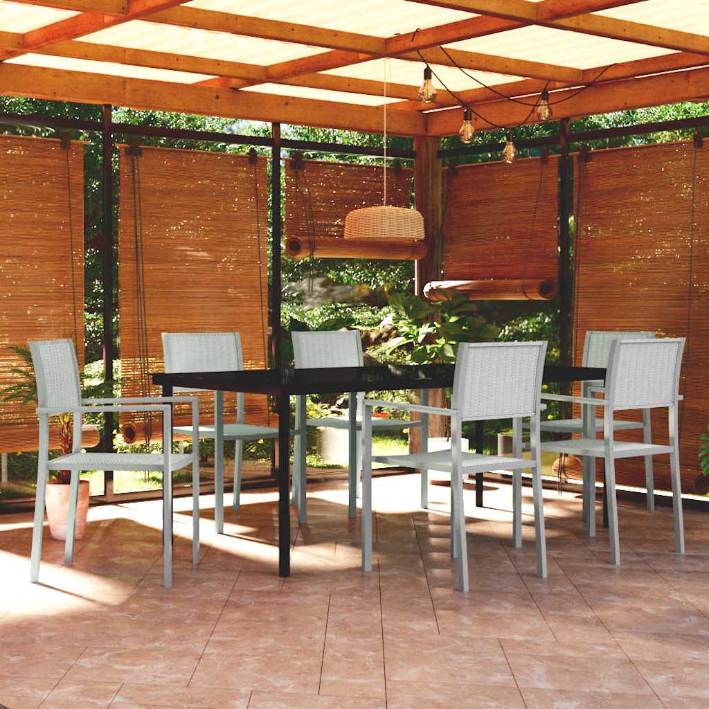 White rattan dining set with black metal frame, side view in a covered patio.