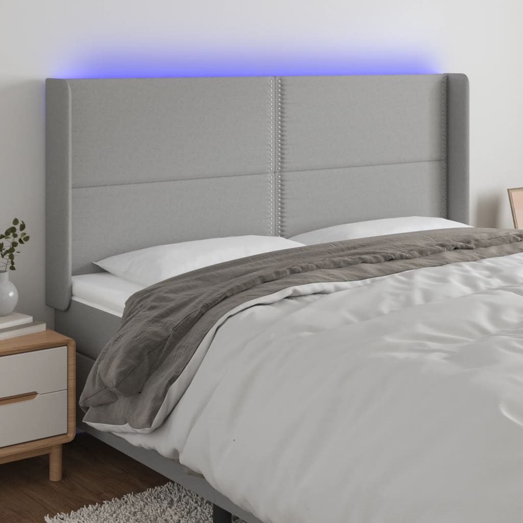 Čelo postele s LED světle šedé 163x16x118/128 cm textil